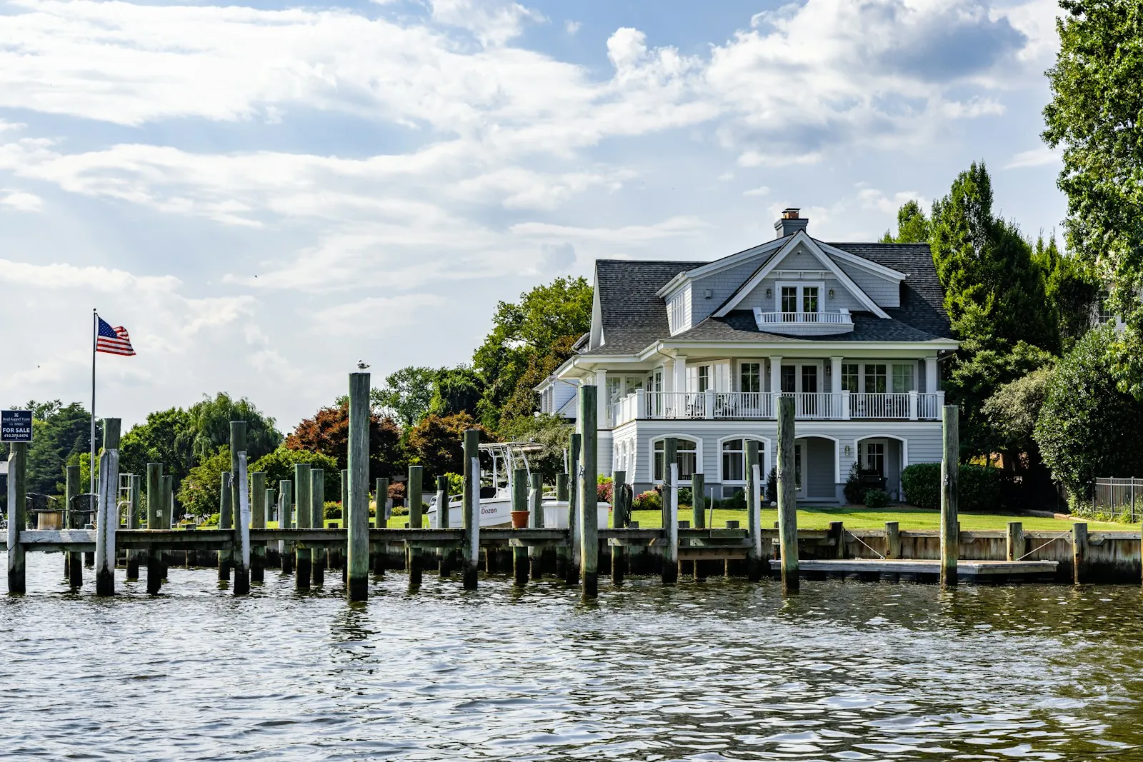 Shingle-style lakefront home with a dock